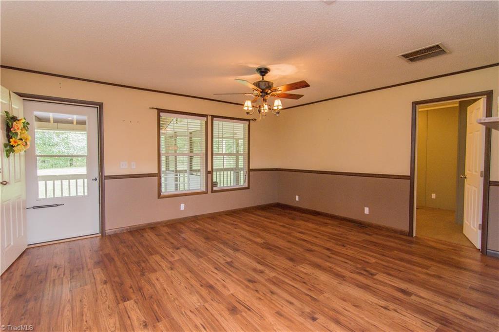 1049 Hickory Fork Road Walnut Cove, NC 27052 - Photo 4 of 24 Enter the home into the large great room with chair rail and laminate flooring.