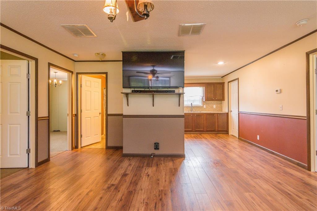 1049 Hickory Fork Road Walnut Cove, NC 27052 - Photo 5 of 24 The home has an open plan with laminate flooring in the great room and eat-in kitchen. It is a split plan with the guest rooms separated from the master bedroom.