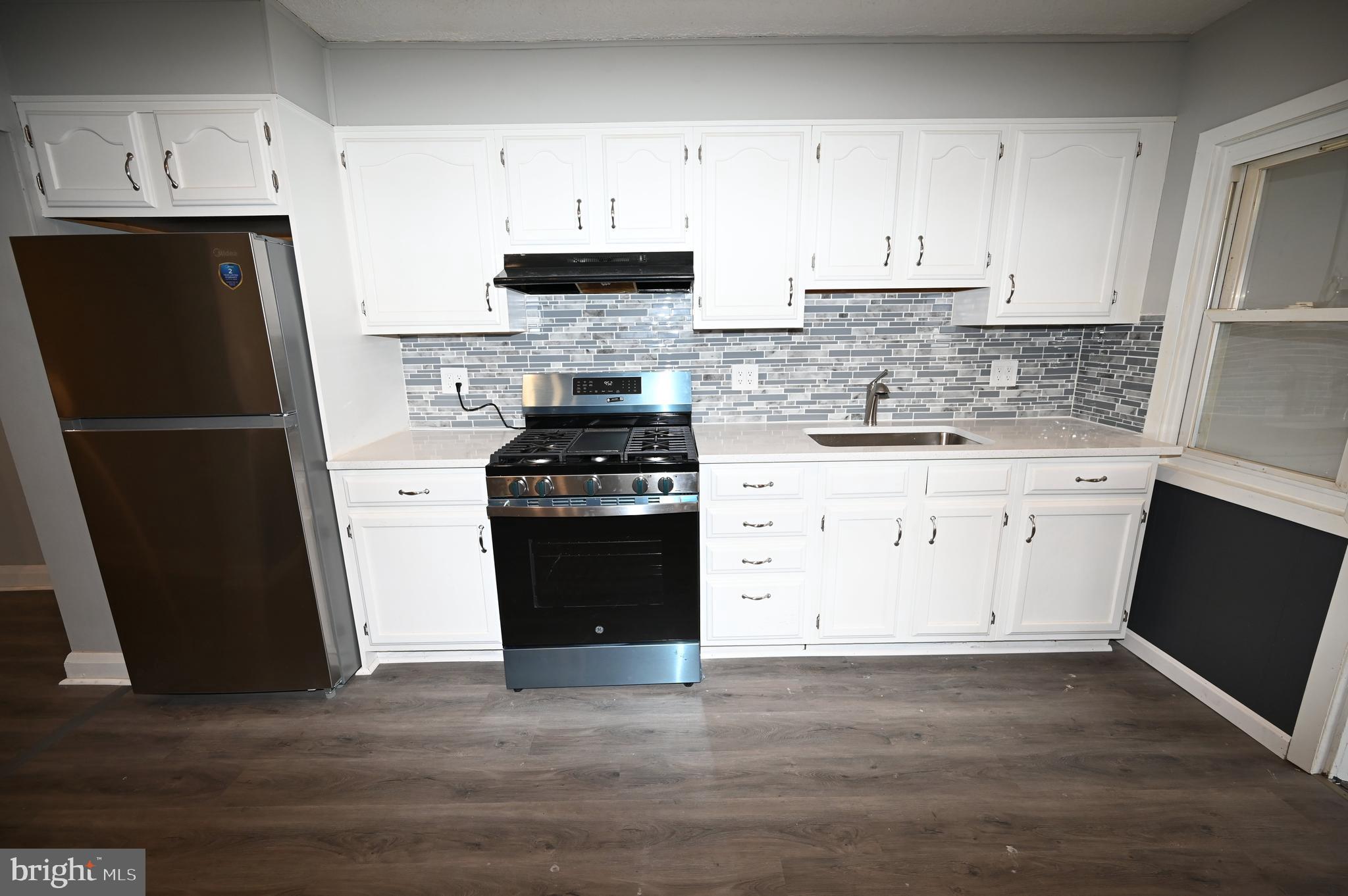 2952 Sollers Point Road, Unit B Dundalk, MD 21222 - Photo 25 of 37 a kitchen with granite countertop white cabinets and refrigerator