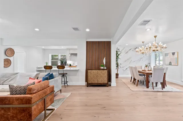 a living room with fireplace furniture and a view of kitchen