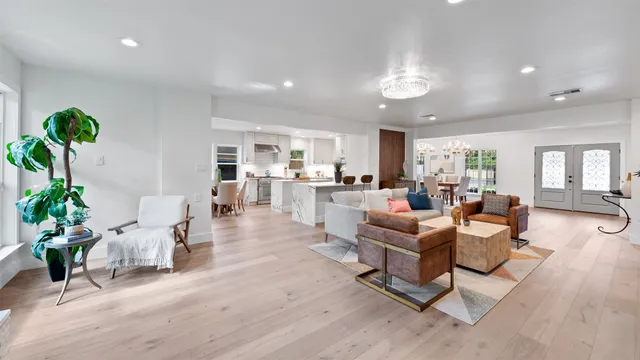 a living room with furniture and a dining table with kitchen view