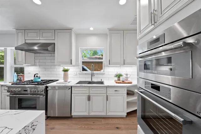 a kitchen with white cabinets and appliances