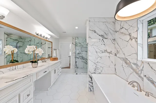 a spacious bedroom with a bed a chandelier and glass door