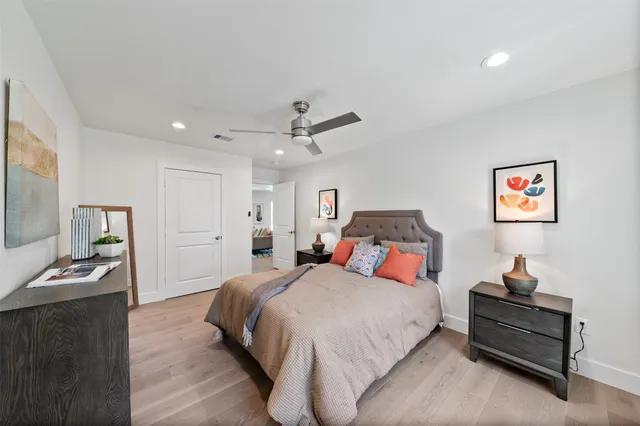 a bedroom with a bed and dresser with mirror