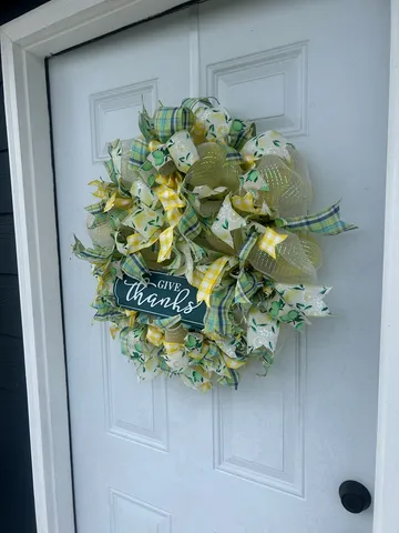 a plant with a white vase with white and yellow flowers
