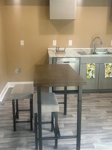 a kitchen with stainless steel appliances a stove a sink cabinets and wooden floor