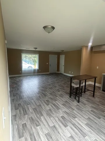 a view of a kitchen with furniture and wooden floor