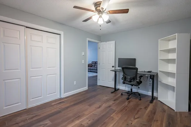 a view of a workspace with furniture and a window