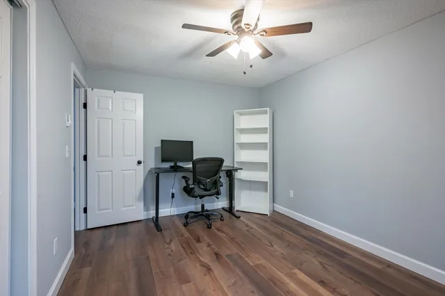 a view of a workspace with furniture and a window