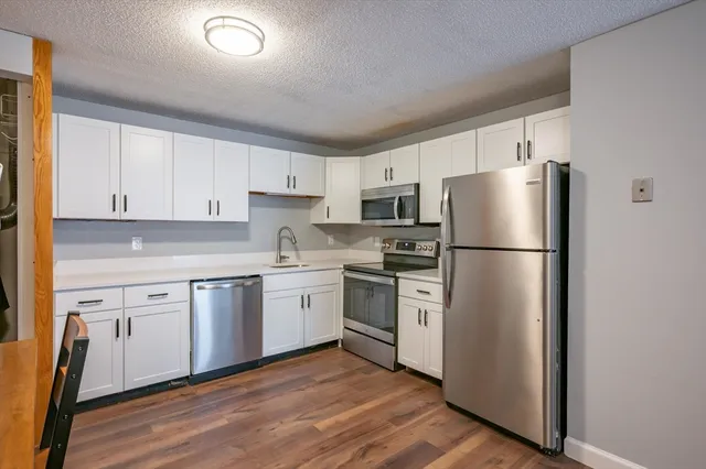 a kitchen with a refrigerator stove and white cabinets