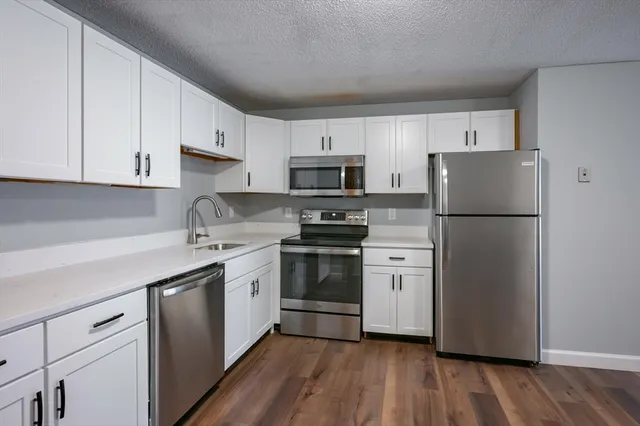 a kitchen with a refrigerator stove and white cabinets