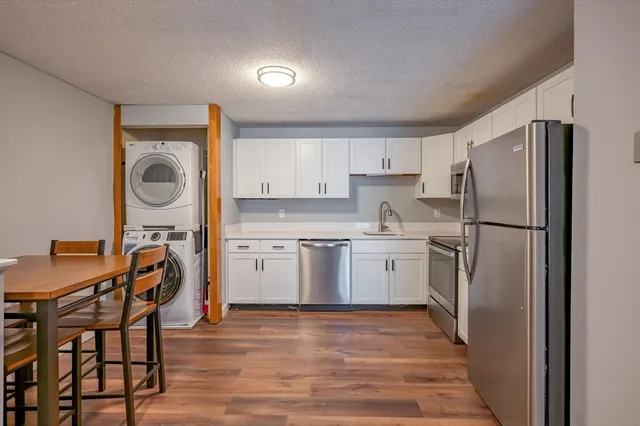a kitchen with a refrigerator sink and cabinets