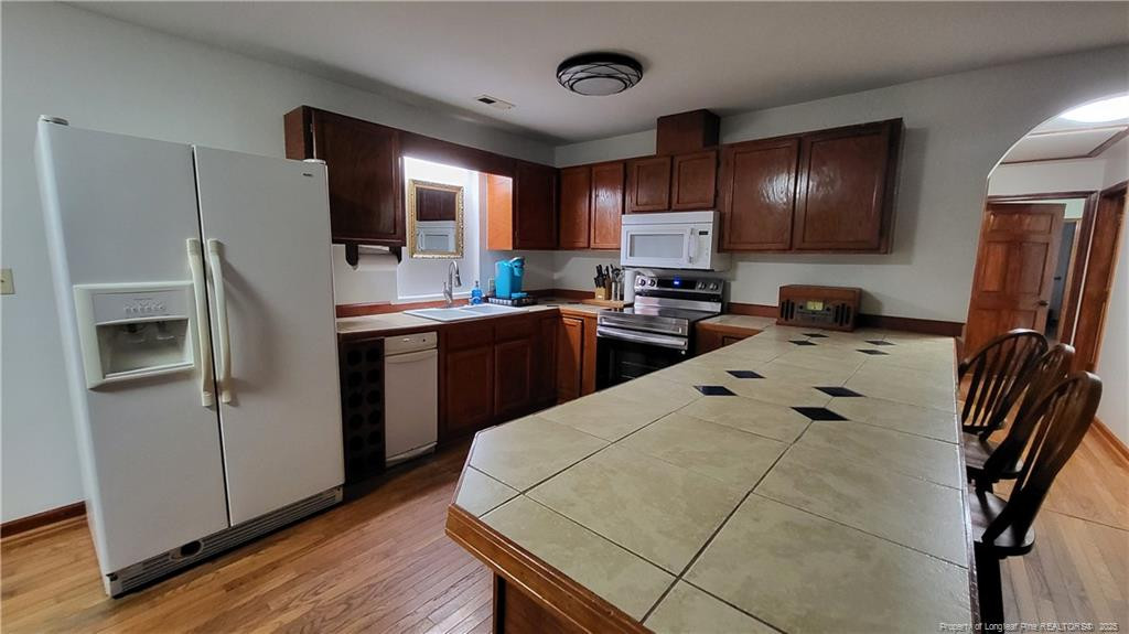 1790 Rozier Church Road Lumberton, NC 28360 - Photo 4 of 12 a kitchen with stainless steel appliances a sink a stove a refrigerator cabinets and wooden floor