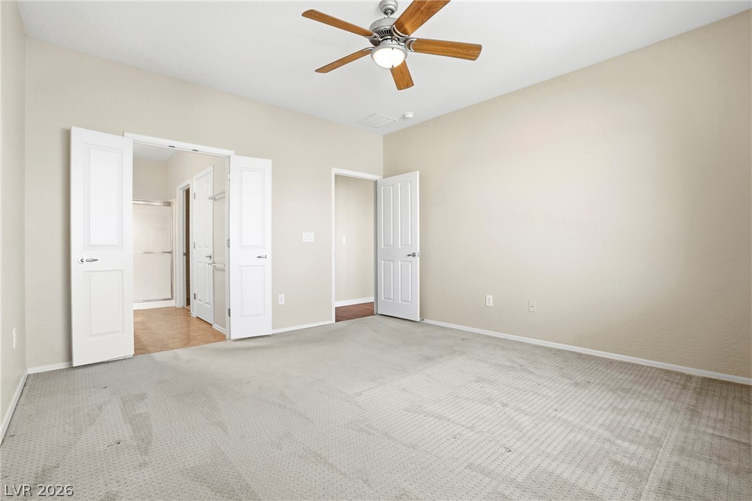 2541 Darda Street Henderson, NV 89044 - Photo 16 of 26 This spacious bedroom offers ample natural light and a serene atmosphere, perfect for relaxation.