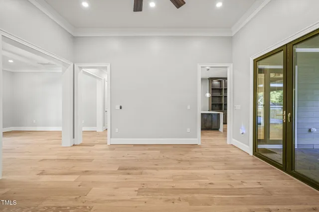 an empty room with fan and a fireplace