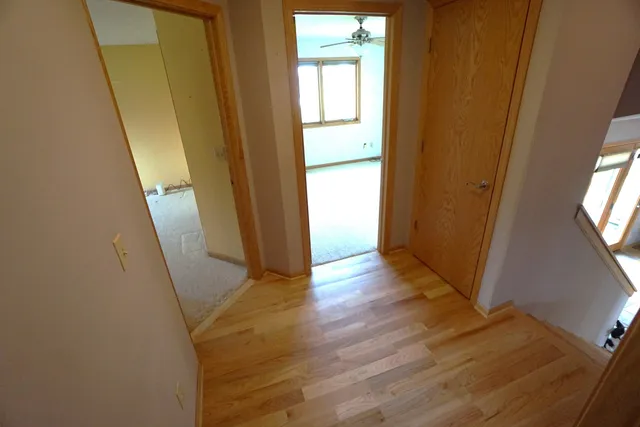 a view of an entryway with wooden floor and door