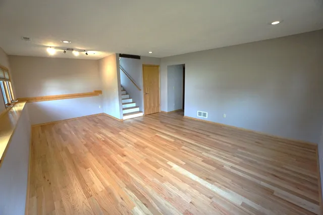 a view of an empty room with wooden floor