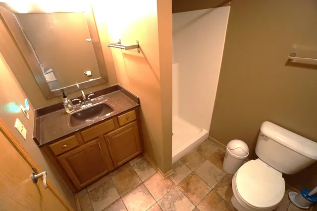 a bathroom with a sink mirror vanity and toilet