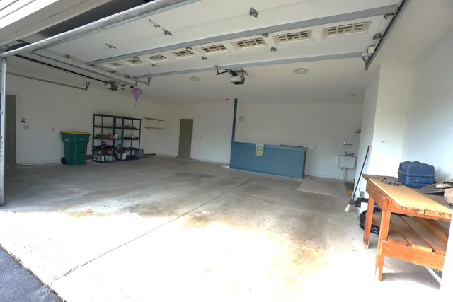 a backyard of a house with large trees and plants