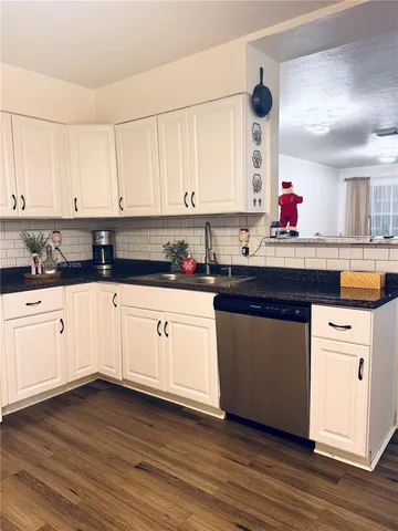 a kitchen with granite countertop a sink and cabinets