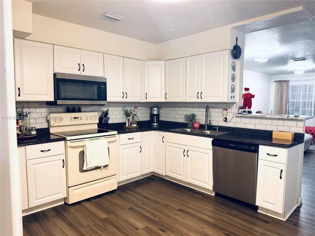 a kitchen with stainless steel appliances white cabinets and a sink