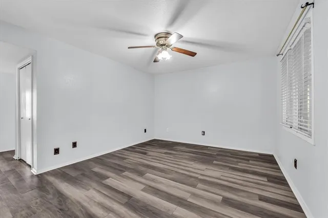 a view of empty room with wooden floor