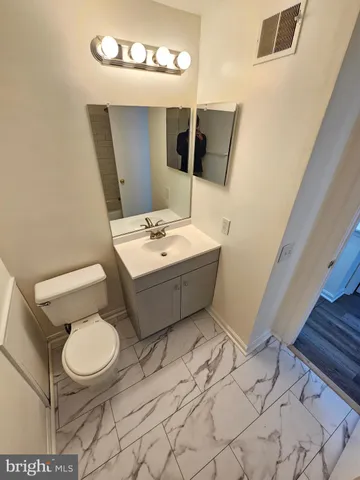 a bathroom with a sink mirror vanity and toilet