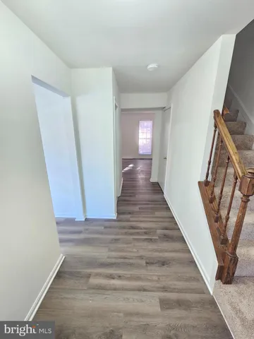 a view of a hallway with wooden floor and stairs