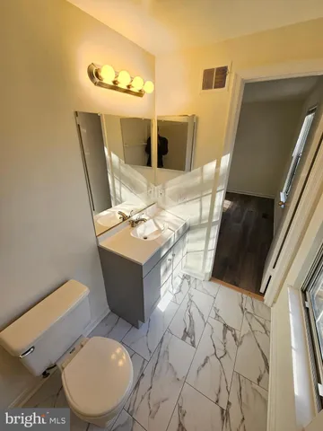 a bathroom with a sink mirror vanity and toilet