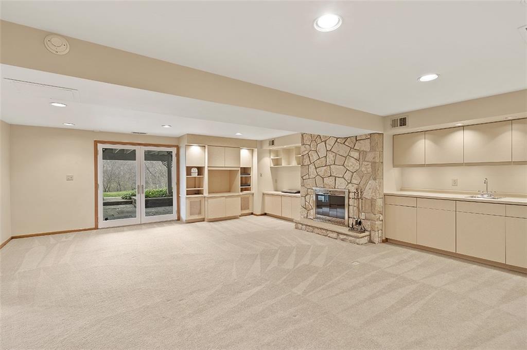 2676 Sunset Lane Allison Park, PA 15101 - Photo 18 of 25 The Amazing Lower Level Game room has New French Doors leading to the covered Flagstone Patio, A Stone Gas Fireplace, Built-in Cabinetry and Recessed Lighting.