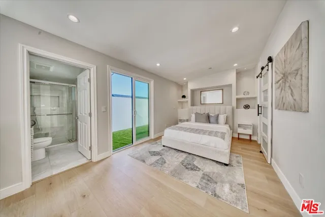 a bedroom with a large bed and a chandelier