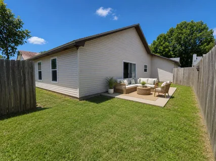 a backyard of a house with table and chairs