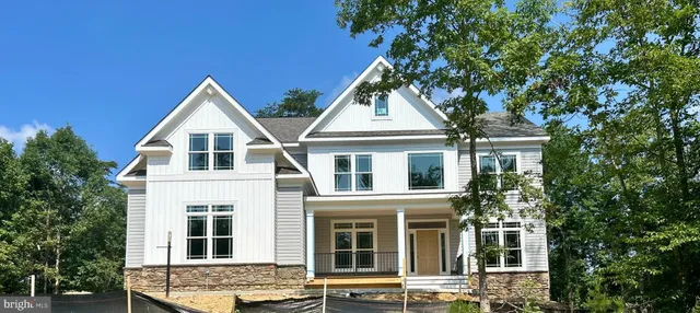 a view of a white house with large windows and a small yard