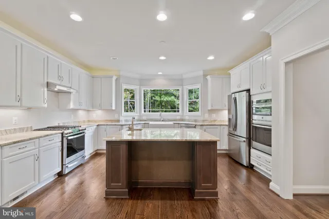a kitchen with granite countertop kitchen island a sink counter space and appliances