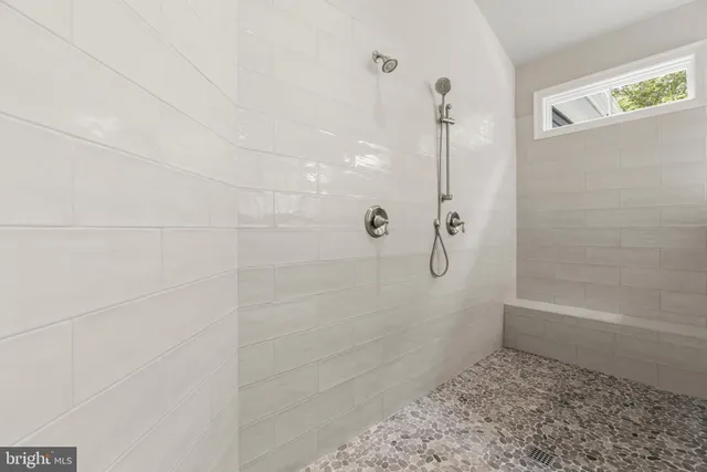 a spacious bathroom with a double vanity sink a large mirror and a bathtub