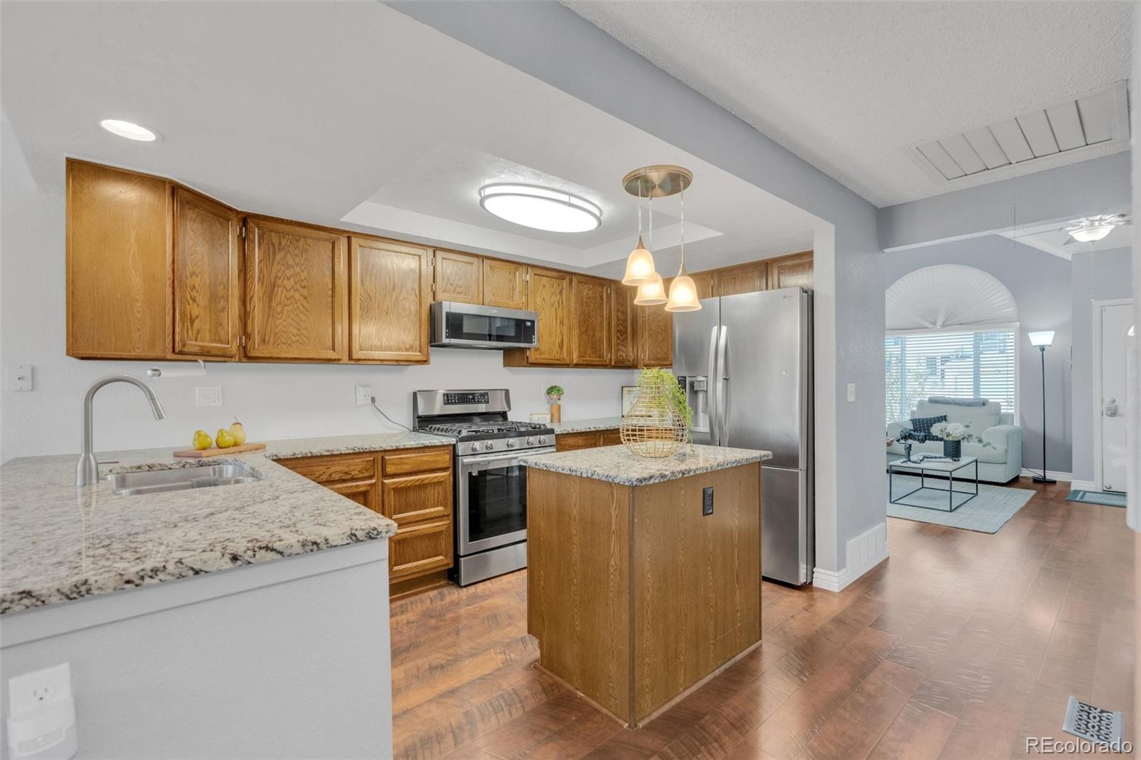 4320 Genoa Street Denver, CO 80249 - Photo 11 of 48 a kitchen with a stove top oven a sink a refrigerator and cabinets