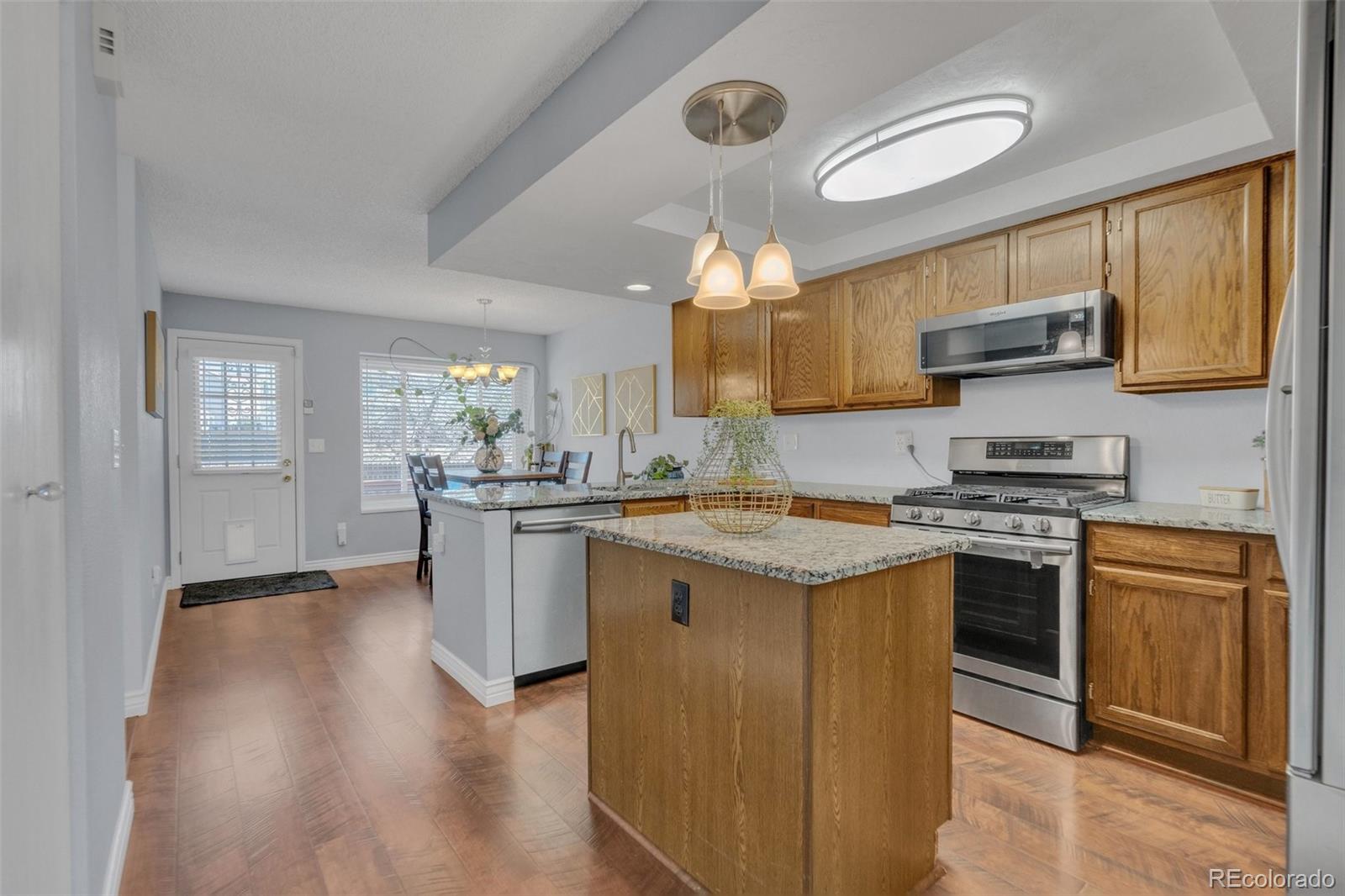4320 Genoa Street Denver, CO 80249 - Photo 12 of 48 a kitchen with stainless steel appliances granite countertop a stove and a sink