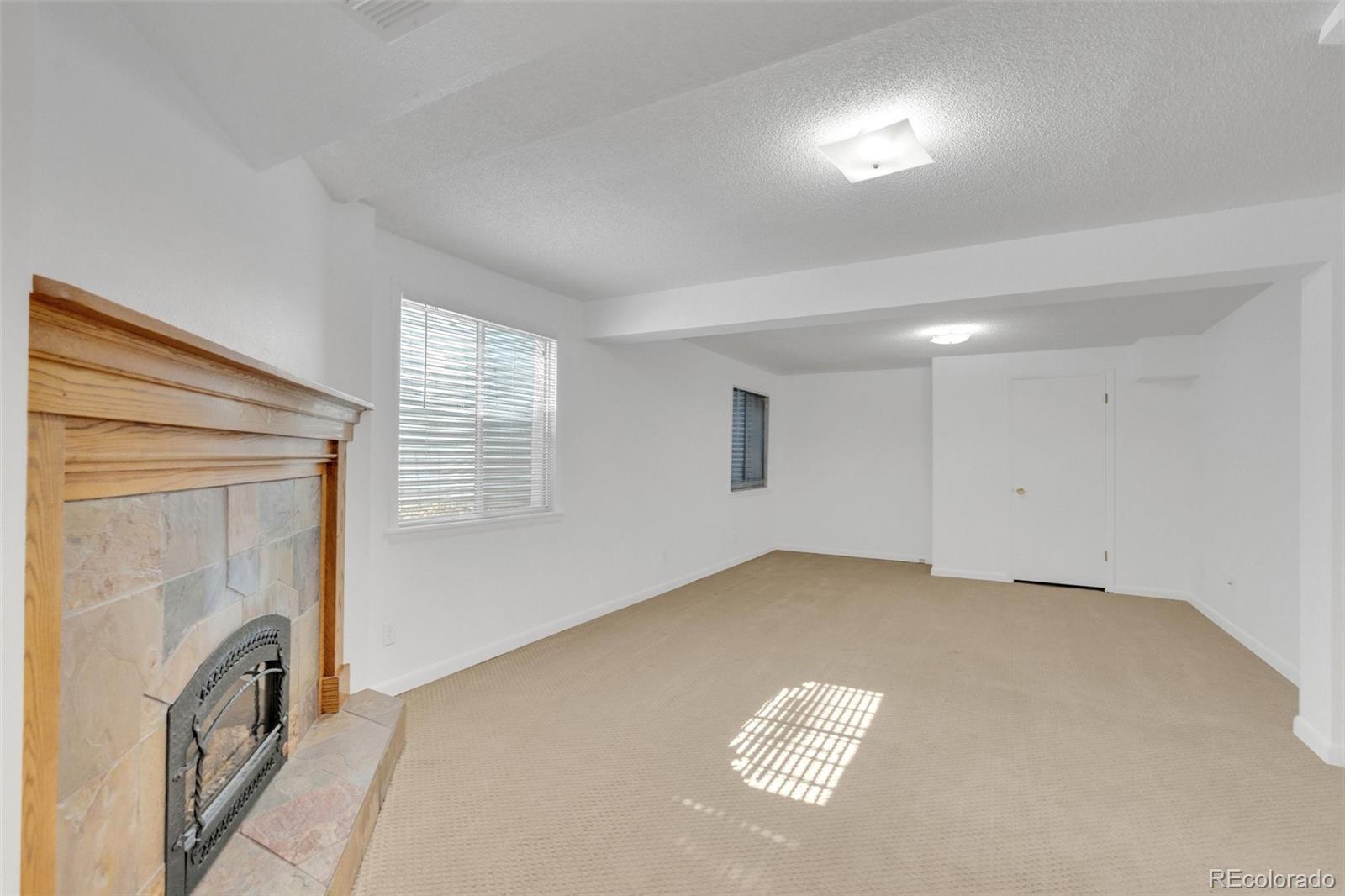 4320 Genoa Street Denver, CO 80249 - Photo 13 of 48 a view of an empty room with a fireplace and a window