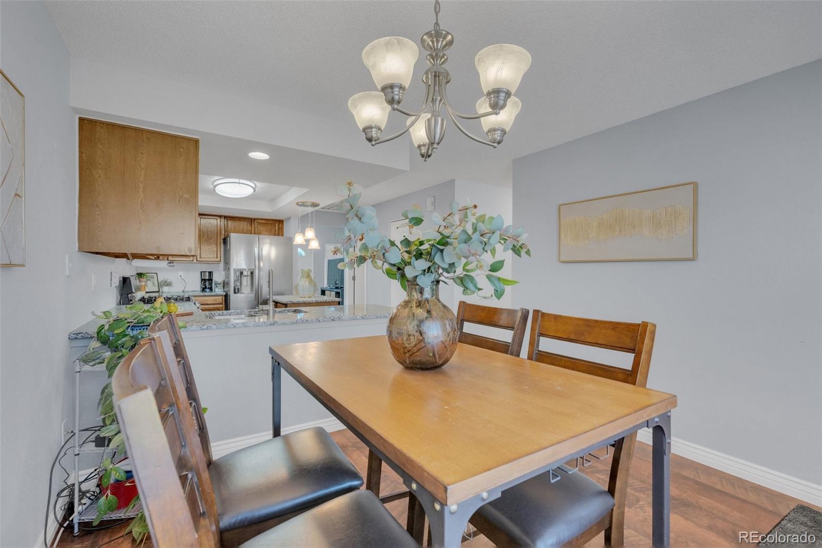 4320 Genoa Street Denver, CO 80249 - Photo 18 of 48 a view of a dining room with furniture and chandelier