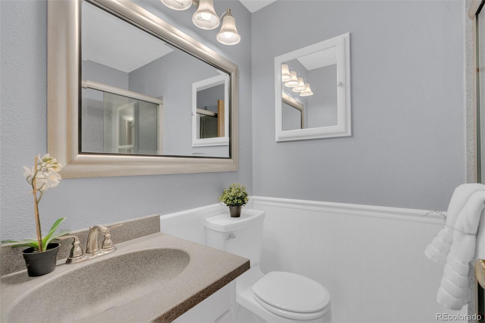 4320 Genoa Street Denver, CO 80249 - Photo 20 of 48 a bathroom with a toilet sink and mirror