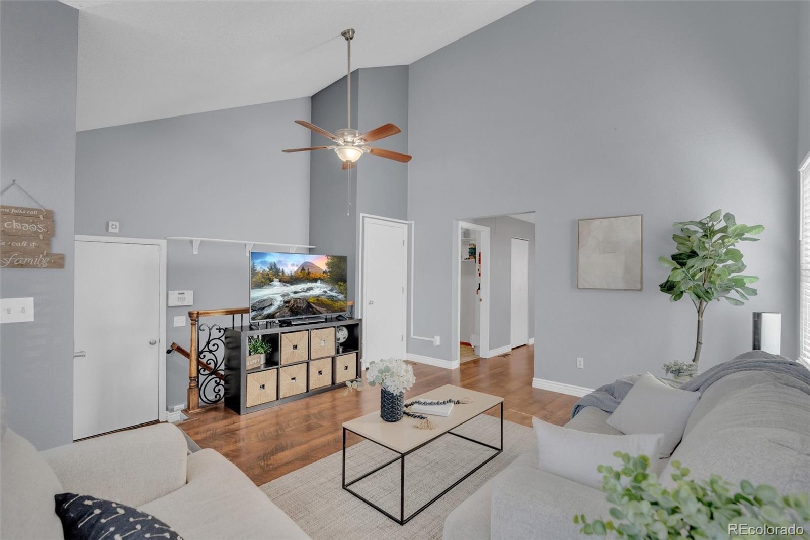 4320 Genoa Street Denver, CO 80249 - Photo 28 of 48 a living room with furniture a chandelier and a potted plant