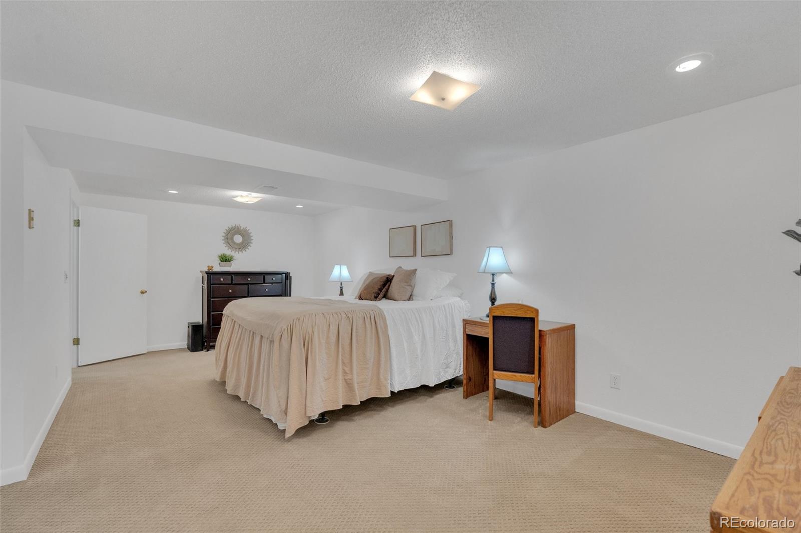 4320 Genoa Street Denver, CO 80249 - Photo 30 of 48 a spacious bedroom with a bed and a lamp
