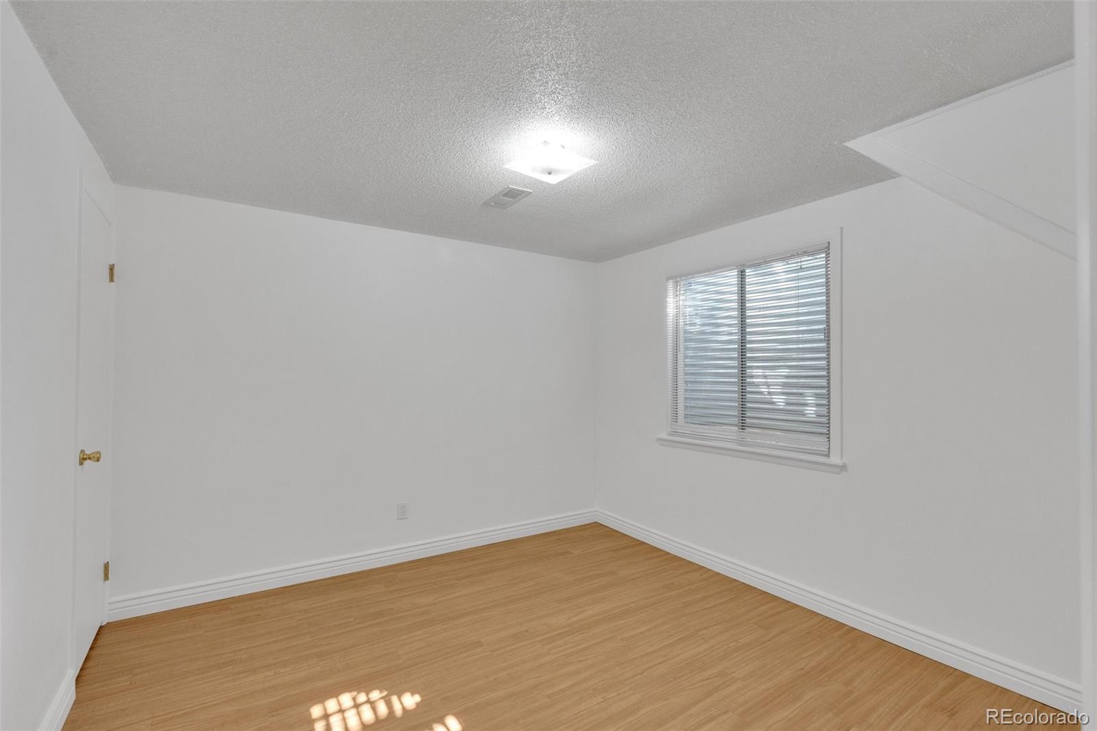 4320 Genoa Street Denver, CO 80249 - Photo 34 of 48 an empty room with wooden floor and windows