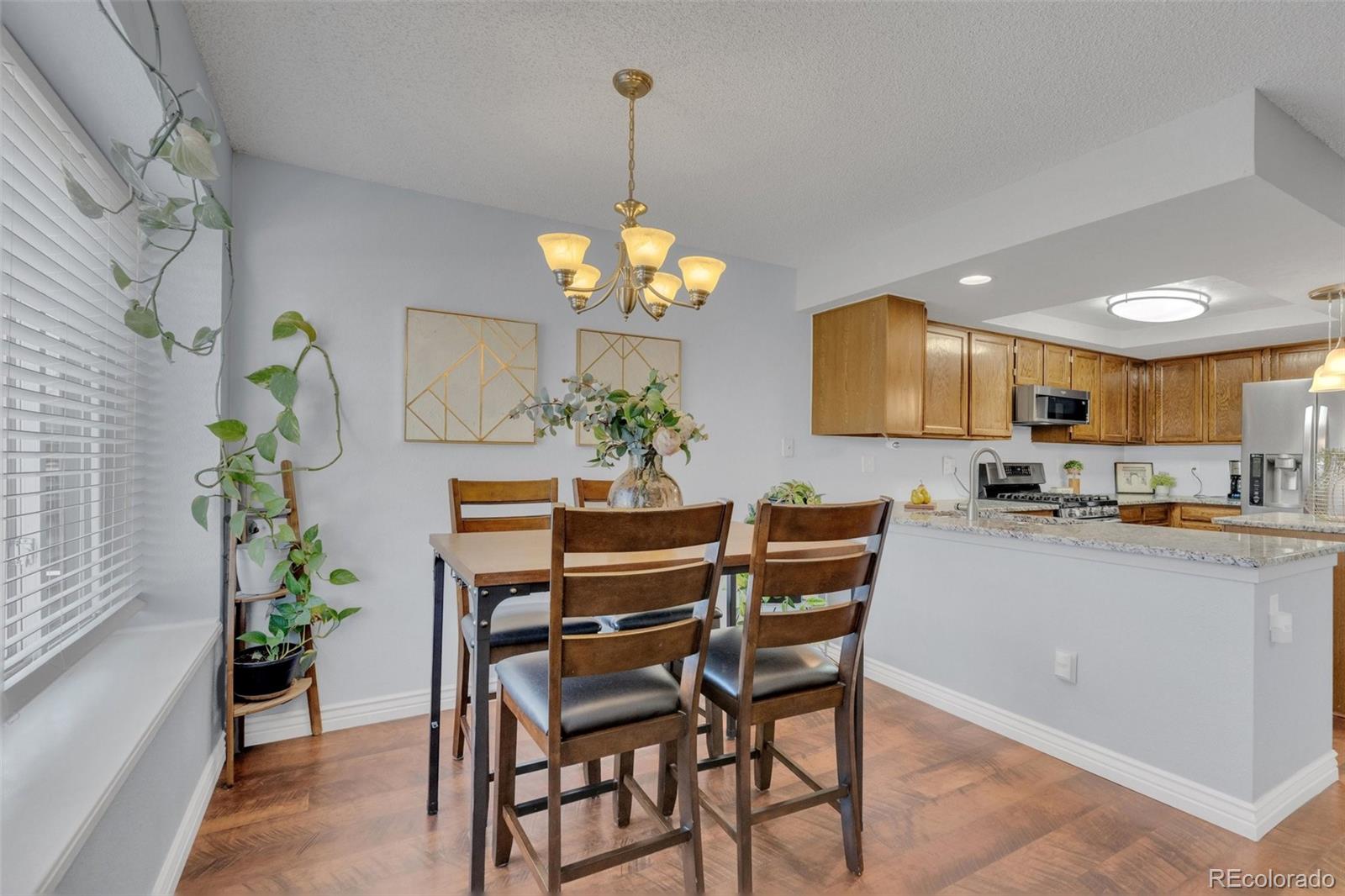 4320 Genoa Street Denver, CO 80249 - Photo 36 of 48 a dining room filled chandelier and wooden floor
