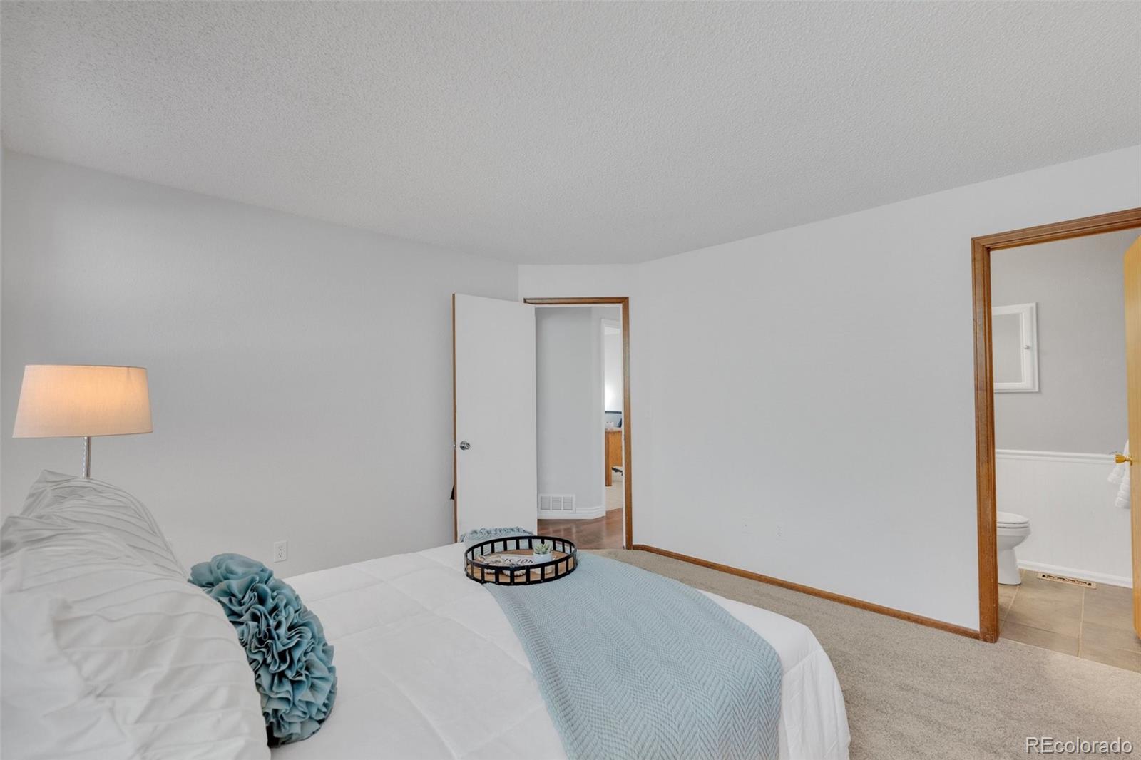 4320 Genoa Street Denver, CO 80249 - Photo 46 of 48 a bedroom with a bed and a lamp on dresser