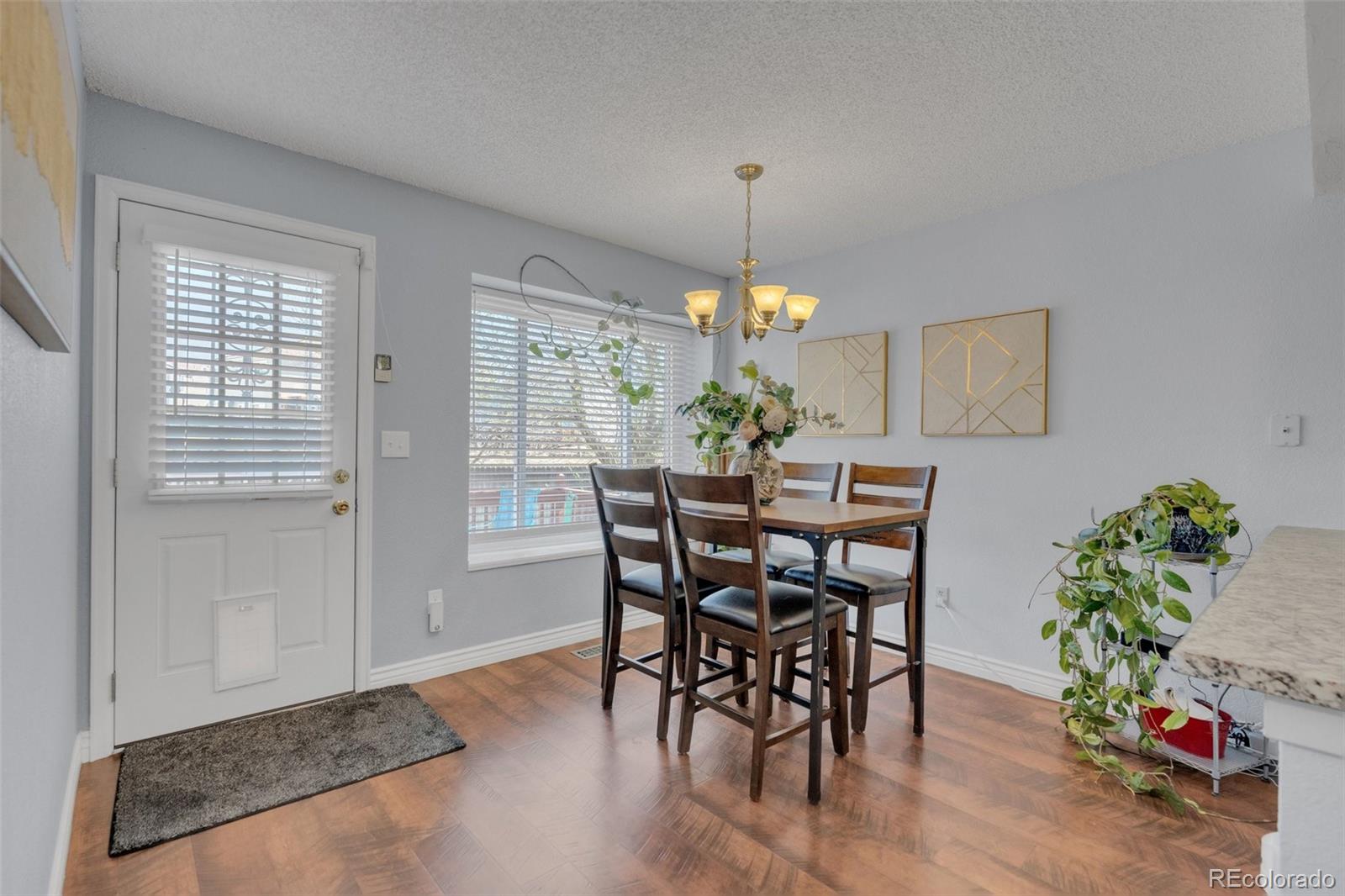 4320 Genoa Street Denver, CO 80249 - Photo 8 of 48 a view of a dining room with furniture and chandelier