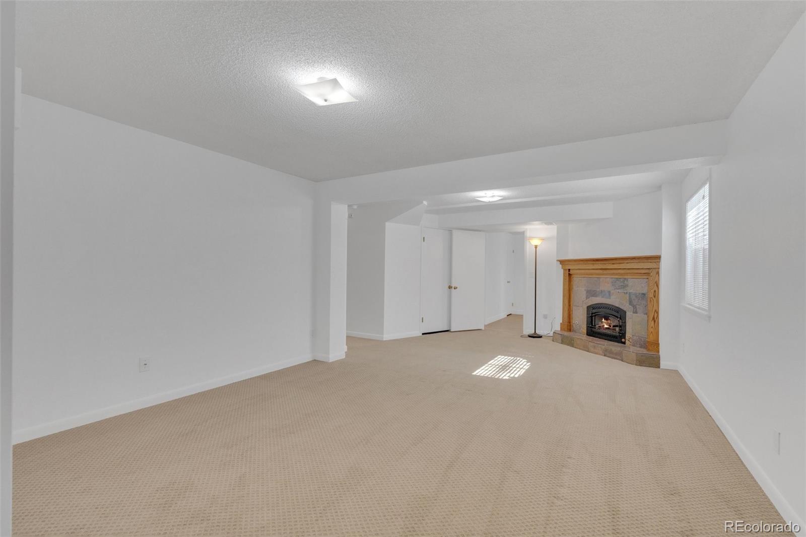 4320 Genoa Street Denver, CO 80249 - Photo 9 of 48 a view of an empty room with a fireplace and a window