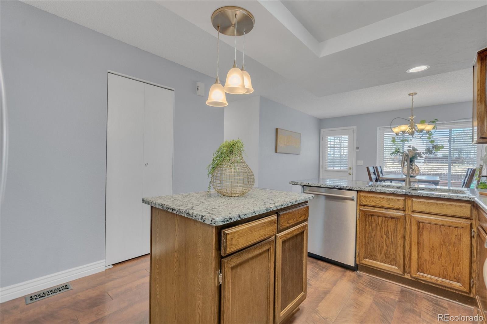 4320 Genoa Street Denver, CO 80249 - Photo 10 of 48 a kitchen with stainless steel appliances granite countertop a sink a stove and a wooden floors