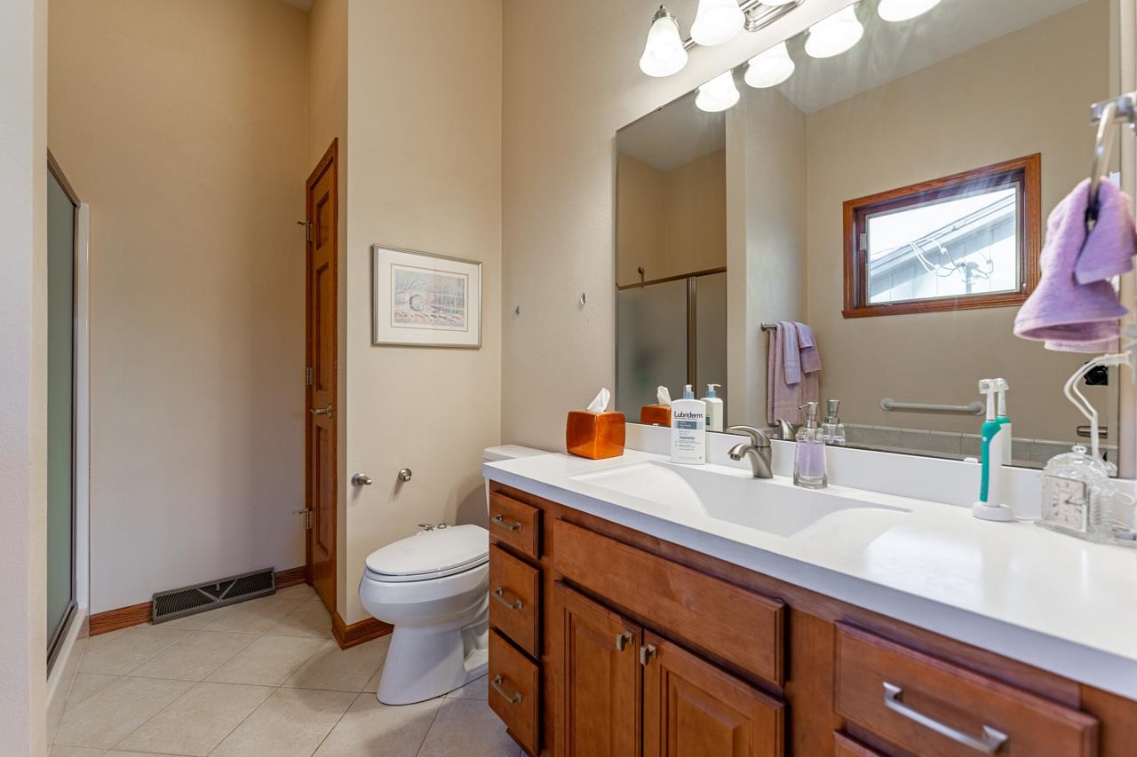 5624 Spring Brook Road Rockford, IL 61114 - Photo 16 of 34 a bathroom with a sink a toilet and a mirror