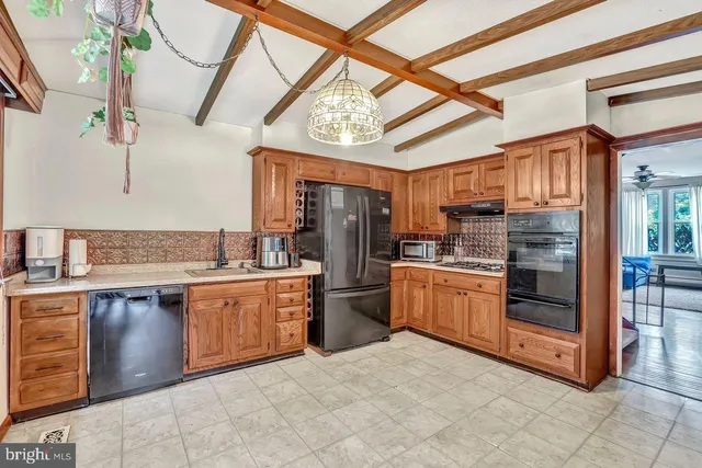 a large kitchen with stainless steel appliances granite countertop a stove and cabinets
